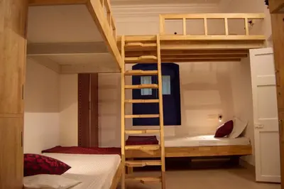 a bunk bed in a room with two beds at Roambay in Mysore