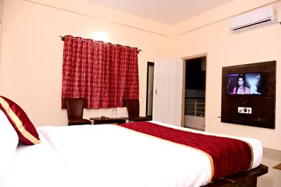 a hotel room with two beds and a flat screen tv at The INN in Mysore