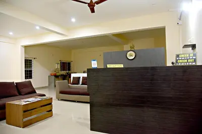 a living room with a couch and a clock on the wall at The INN in Mysore