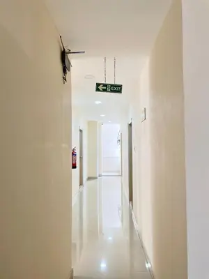 a hallway in a building with a sign on the wall at The INN in Mysore