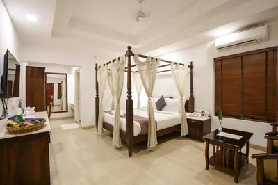 a bedroom with a four poster bed in a room at Once Upon The River, Aluva - Near Cochin International Airport in Cochin