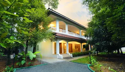 a house with a balcony on the side of it at Once Upon The River, Aluva - Near Cochin International Airport in Cochin