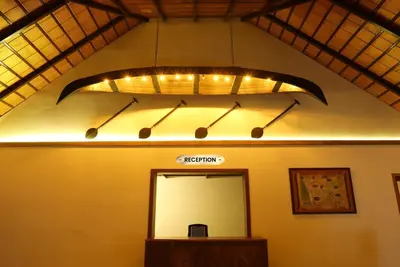 a bathroom with a mirror and a light on the wall at Once Upon The River, Aluva - Near Cochin International Airport in Cochin