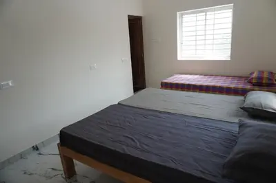 a bedroom with a bed and a window at Cornerbunker in Mysore