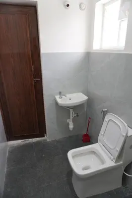 a bathroom with a toilet and a sink at Cornerbunker in Mysore