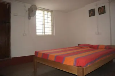 a bedroom with a bed in a room with a window at Cornerbunker in Mysore