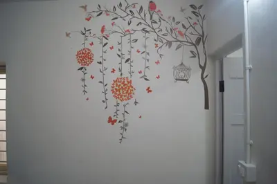 a wall mural of a tree with a bird and a lantern at Cornerbunker in Mysore