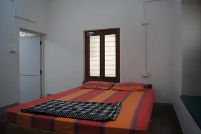 a bed in a room with a window at Cornerbunker in Mysore