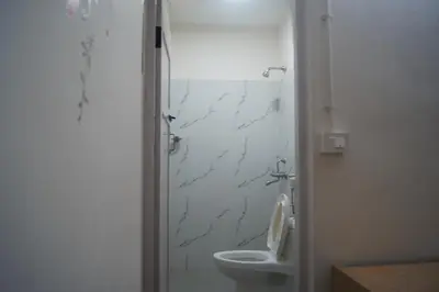 a bathroom with a toilet and a shower at Cornerbunker in Mysore