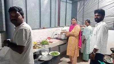 a group of people in a kitchen preparing food at Ammu's home stay in Panamaram