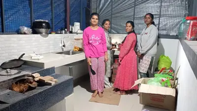 a group of people standing in a kitchen at Ammu's home stay in Panamaram