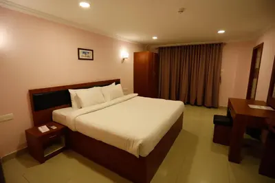 a hotel room with a bed and a desk at Luxora Hotel and Spa in Kozhikode