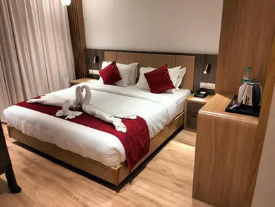 a hotel room with a bed with two rabbits on it at GAYATHRI HOTELS in Badagara