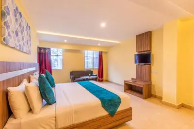 a hotel room with a bed and a television at Vinayaga Inn by Poppys, Ooty in Ooty