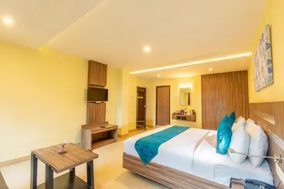 a bedroom with a large bed and a table at Vinayaga Inn by Poppys, Ooty in Ooty