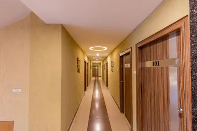 a hallway of a hospital with a door with the number at Vinayaga Inn by Poppys, Ooty in Ooty