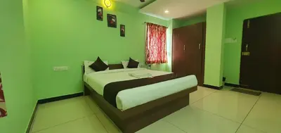 a bedroom with a bed in a green room at JR Guest Home in Coimbatore