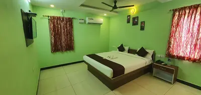 a bedroom with a bed with green walls at JR Guest Home in Coimbatore