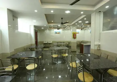 a large room with tables and chairs in a building at JR Guest Home in Coimbatore