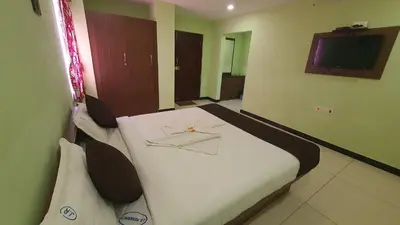 a hotel room with a bed with a ring on it at JR Guest Home in Coimbatore