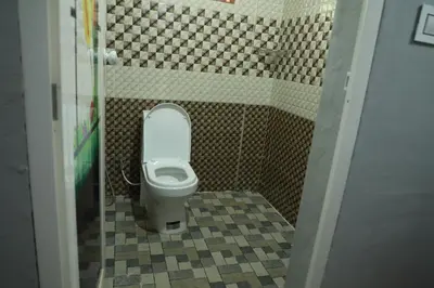 a bathroom with a toilet in a bathroom stall at kailasa stays in Chekadi