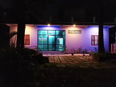 a house lit up at night with blue lights at kailasa stays in Chekadi