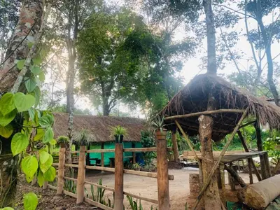 a hut with a fence and a wooden table at kailasa stays in Chekadi