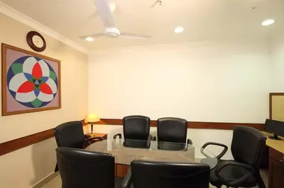 a conference room with chairs and a table and a clock at Hotel CLOUD 9 in Kotamangalam