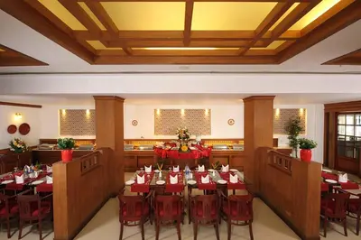 a dining room with tables and chairs in a room at Hotel CLOUD 9 in Kotamangalam
