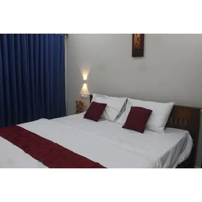 a bedroom with a white bed with red pillows at Nature Villa Kochi in Alwaye
