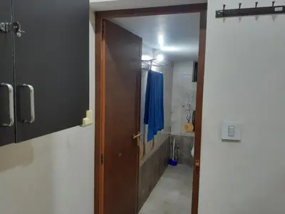 an open door to a bathroom with a blue curtain at Nature Villa Kochi in Alwaye