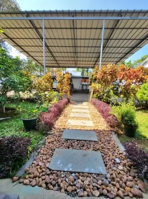 a garden with a stone walkway and a pergola at Nature Villa Kochi in Alwaye