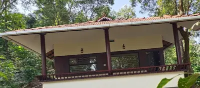 a house with a wrap around porch at Green Garden Lotus in Vythiri
