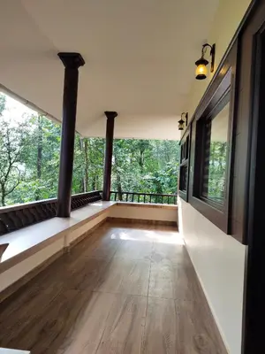 a room with large windows and wooden floors at Green Garden Lotus in Vythiri