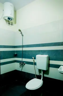 a bathroom with a toilet and a sink at Green Garden Lotus in Vythiri