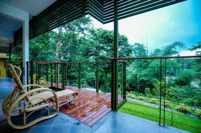 a screened in porch with a bench on a deck at Kuruva Island Resort And Spa - By KABINI BREEZE in Mananthavady