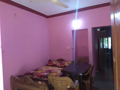 a bedroom with a bed and a table in a room at Dreams River view Homestay Coorg in Kushālnagar