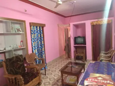 a living room with pink walls and a table at Dreams River view Homestay Coorg in Kushālnagar