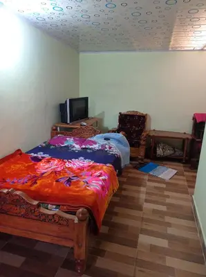 a bedroom with a bed and a tv in it at Dreams River view Homestay Coorg in Kushālnagar