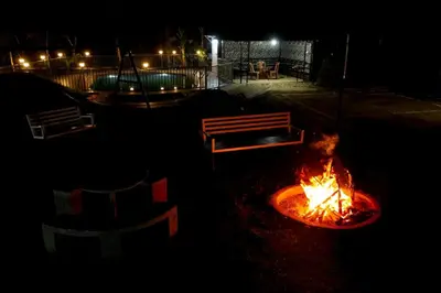 a fire pit with a bench next to a fire pit at Viewpointwayanad in Mananthavady