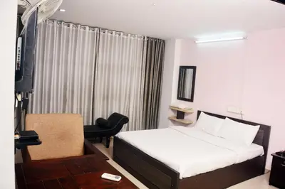 a bedroom with a bed and a chair and a television at MALAPPURAM RESIDENCY in Malappuram