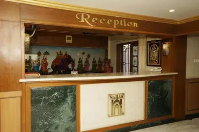 a reception counter in a building with a sign at Hotel Nahar Manchester Inn in Coimbatore