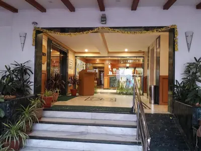 an entrance to a building with stairs and plants at Hotel Nahar Manchester Inn in Coimbatore