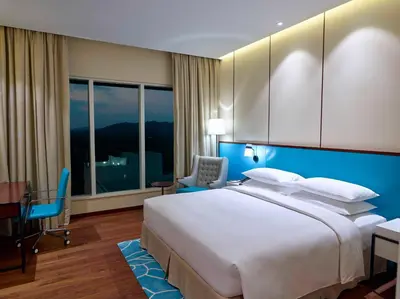 a bedroom with a large white bed and a desk and chair at Hyatt Regency Thrissur in Trichūr