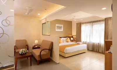 a hotel room with a bed and a chair at Flora Charishma Residency Aluva in Cochin