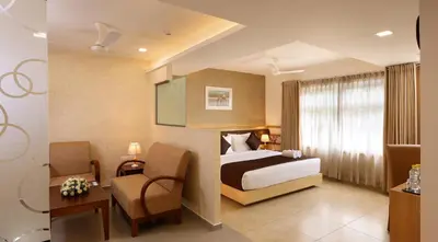 a hotel room with a bed and a chair at Flora Charishma Residency Aluva in Cochin
