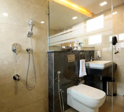 a bathroom with a shower and a toilet and a sink at Flora Charishma Residency Aluva in Cochin