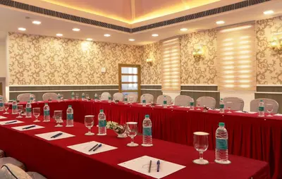 a long table with glasses and bottles of water on it at Flora Charishma Residency Aluva in Cochin