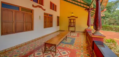 a room with a wooden bench in a house at amã Stays & Trails, Rare Earth Estate in Madikeri
