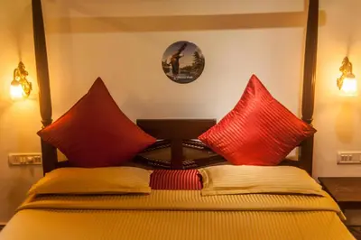 a bedroom with two red pillows on a bed at amã Stays & Trails, Rare Earth Estate in Madikeri
